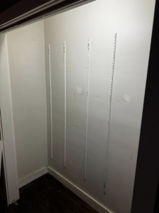 Metal tracks installed on a closet wall for shelving by Premier Handyman Services in Lexington, KY.