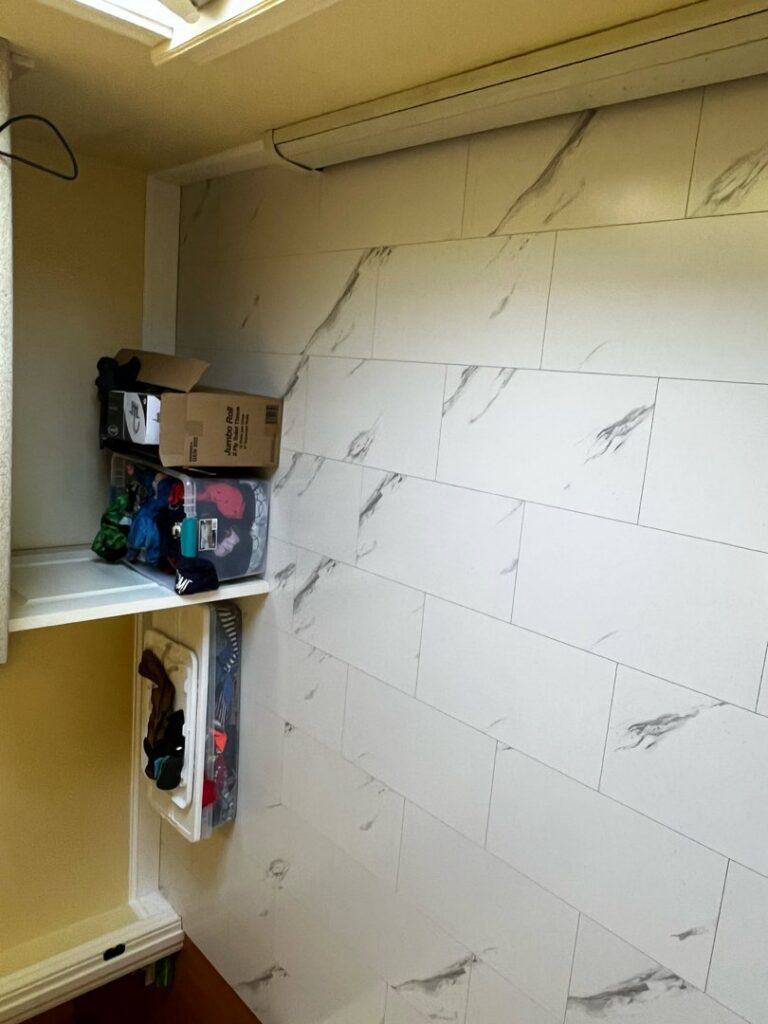 A closet featuring newly installed faux marble wall paneling, completed by Sini's Handyman Services in Falmouth, ME.