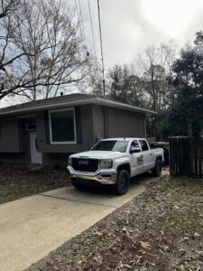 A Clutter Control Junk Removal and Demo truck and trailer parked at a residential property in Biloxi, MS, ready for a job.