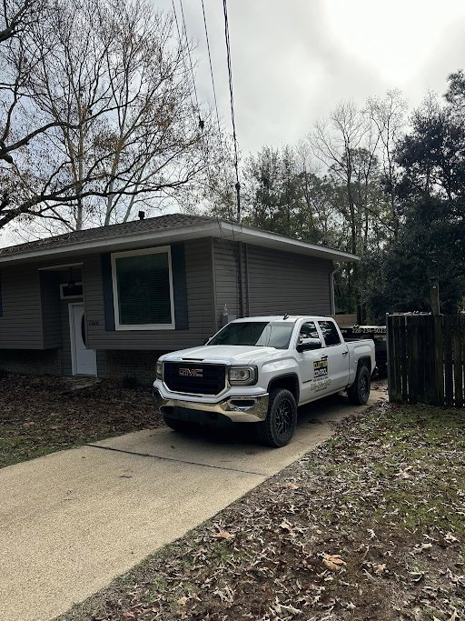 A Clutter Control Junk Removal and Demo truck and trailer parked at a residential property in Biloxi, MS, ready for a job.