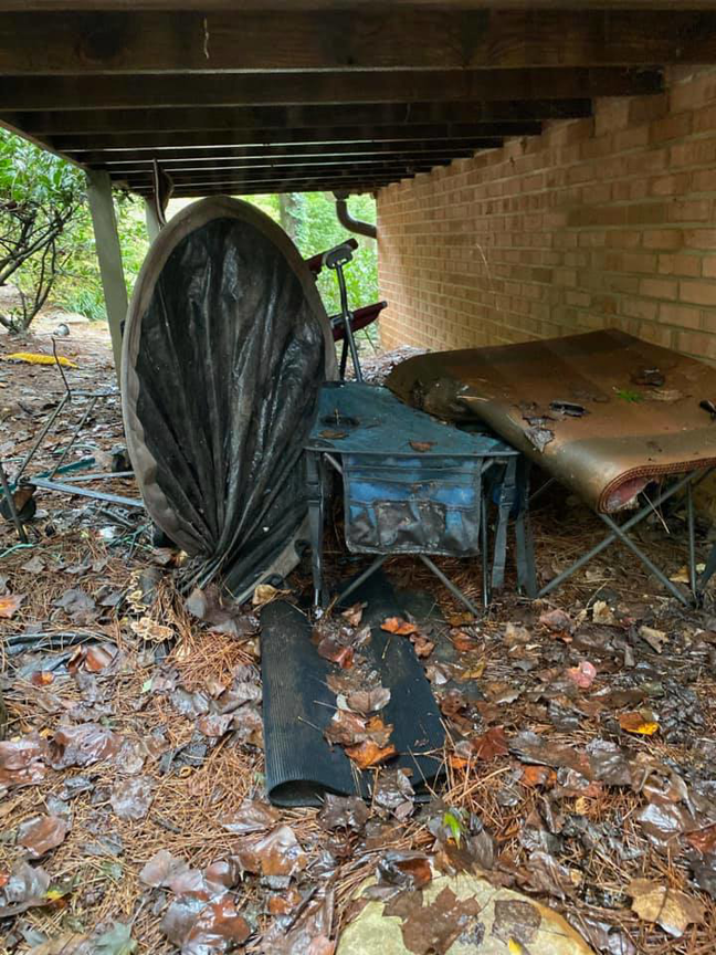 A cluttered area under a deck with various discarded items before junk removal by Hiatts Hauling Junk Removal in Knoxville, TN