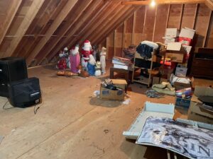 A cluttered attic filled with various items and junk, awaiting a professional house cleanout by Tj's junk removal LLC in Derry, NH.
