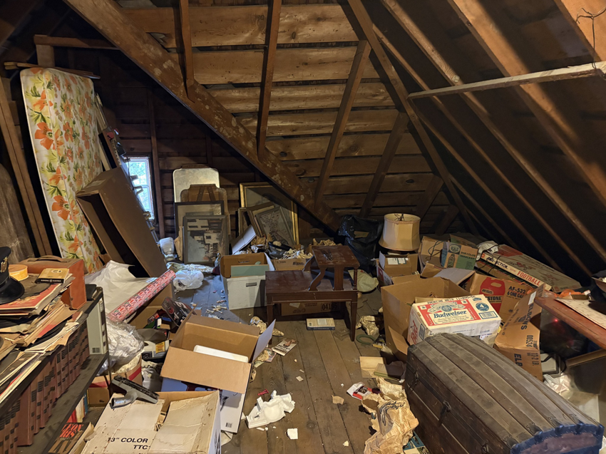 A cluttered attic filled with old furniture and boxes, ready for junk removal by Mission Haulers in Solvay, NY.