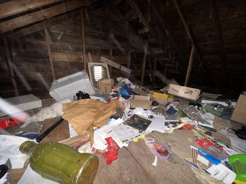 A very cluttered attic space filled with boxes, papers, and old items for junk removal by Vargas Junk Removal & Dumpster Rentals in Urbandale, IA.