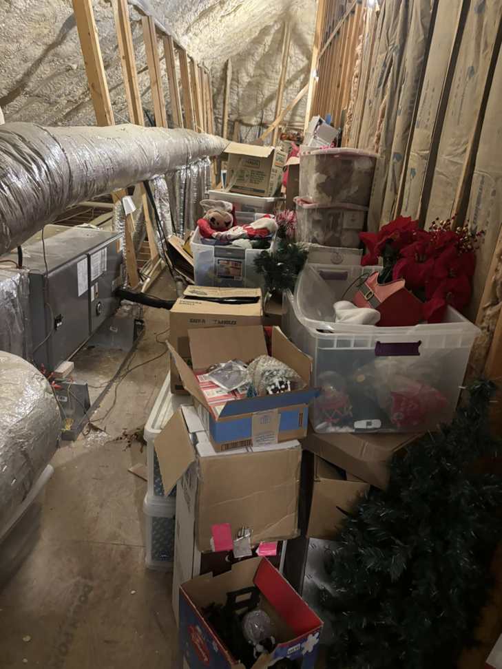 A cluttered attic storage space filled with boxes and miscellaneous items, ready for cleanup by Nash's Cargo Company LLC in Shreveport, LA.