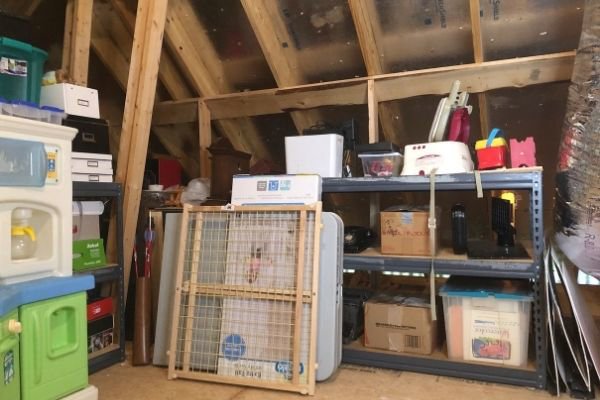 A cluttered attic storage space filled with boxes and various items, ready for junk removal by Got Rubbish in Jersey City, NJ