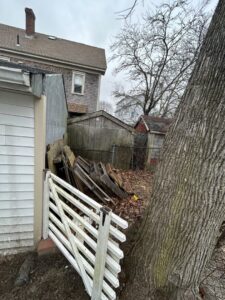 A cluttered backyard with old wood, debris, and a shed, awaiting junk removal by CK Junk Removal in New Bedford, MA