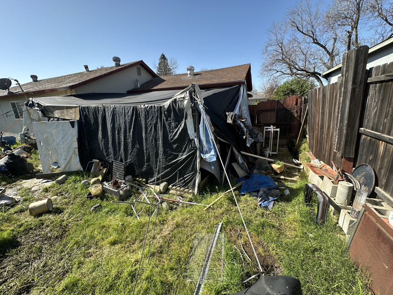 A cluttered backyard full of debris and junk ready for removal by Junk Guys Sacramento in Roseville, CA.