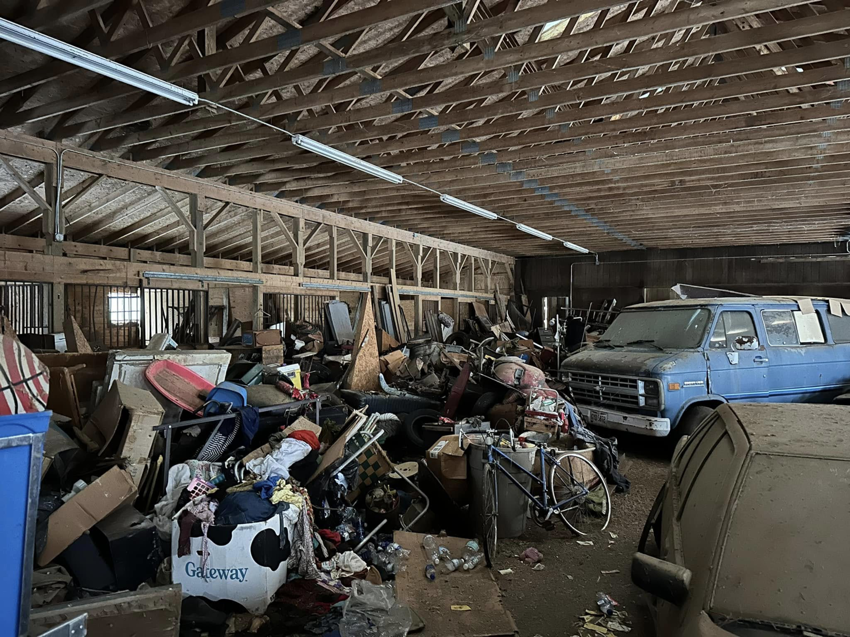 A heavily cluttered barn filled with junk, ready for general junk removal by White Dumpster in Alliance, OH.