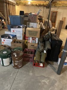 A large pile of miscellaneous junk, boxes, and old items cluttering a basement, ready for removal by Vatter Hauling Service in Lancaster, PA.