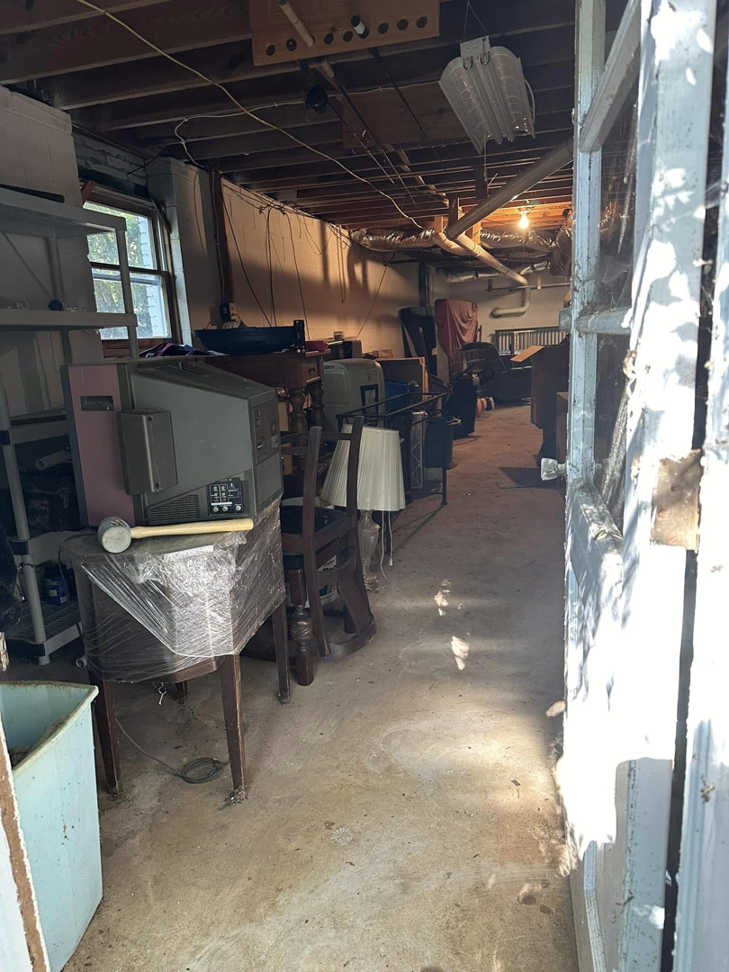A cluttered basement filled with old electronics, furniture, and lamps, ready for junk removal by Pop's Pickup Junk & Trash Removal in Roswell, GA.
