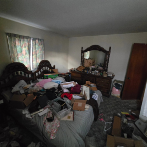 A heavily cluttered bedroom with a bed and dresser, ready for decluttering and organization by 1st State's Finest LLC, a handyman in Middletown, DE.