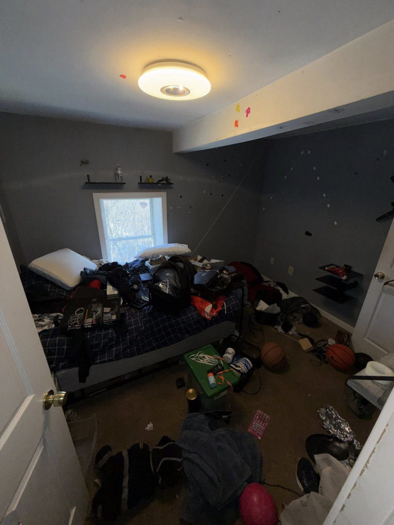 A very cluttered bedroom with items on the bed and floor, illustrating a space before junk removal by DJ's Junk Removal in Laconia, NH.