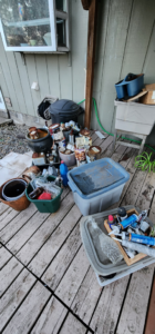 A cluttered residential deck filled with various items and debris before junk removal by AG Junk Haulers in Salem, OR.