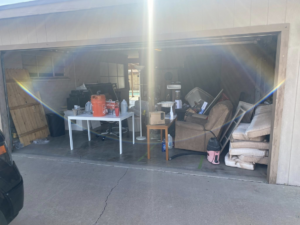 A cluttered garage filled with various items before a junk removal service by Bin There Junk That in Phoenix, AZ.