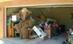 A cluttered garage filled with boxes and various items, ready for general junk removal by Harvey's Junk Hauling and Recycling LLC in Scottsdale, AZ.