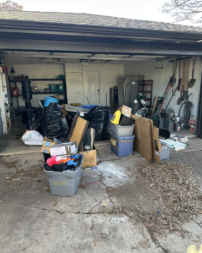 A cluttered garage filled with trash bags, boxes, and various items before junk removal by Junked Up Junk Removal in Watauga, TX.