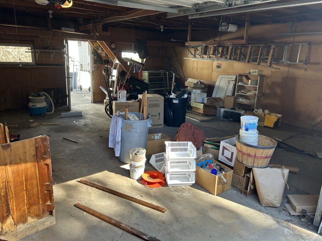 A cluttered garage filled with various items and debris, awaiting junk removal by Mr. Groundhog Disposal and Services in Bloomington, MN.
