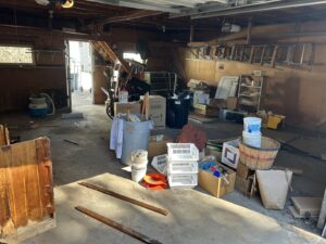 A cluttered garage filled with various items and debris, awaiting junk removal by Mr. Groundhog Disposal and Services in Bloomington, MN.