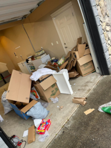 A cluttered garage filled with cardboard boxes and miscellaneous trash, awaiting junk removal by Xtreme Haul in Vancouver, WA.