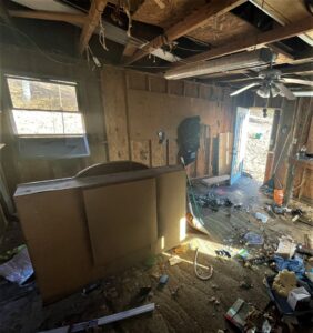 A cluttered garage interior with various junk and debris on the floor, awaiting cleanout by Removall Residential and Commercial Cleanout Services in York, PA.