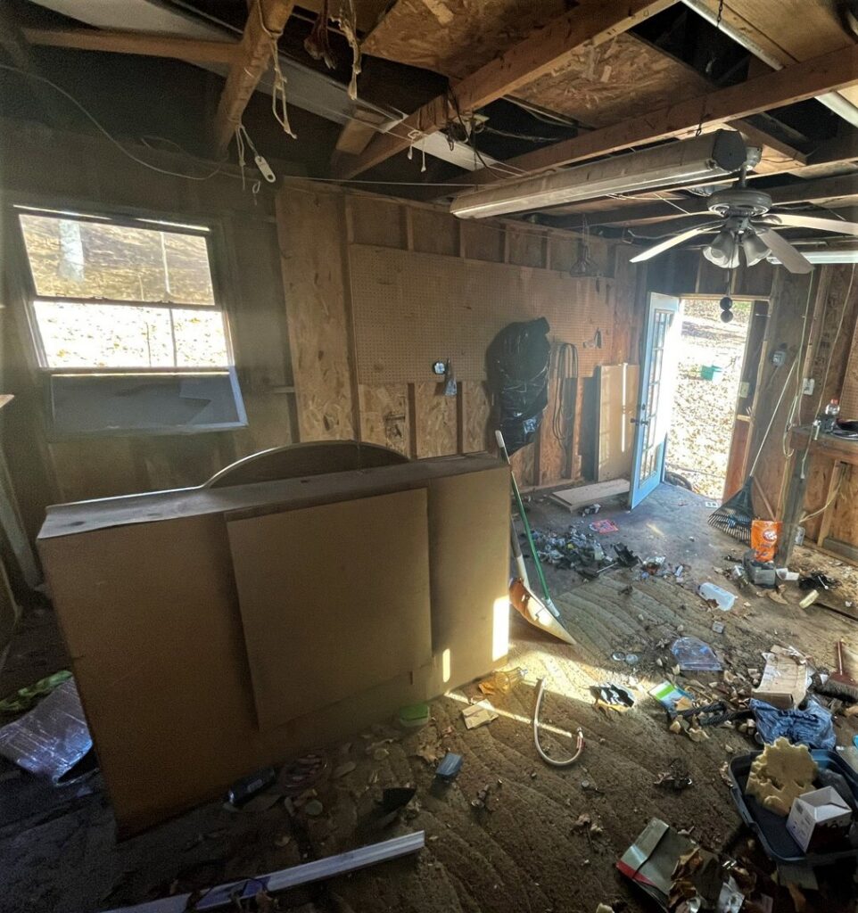 A cluttered garage interior with various junk and debris on the floor, awaiting cleanout by Removall Residential and Commercial Cleanout Services in York, PA.