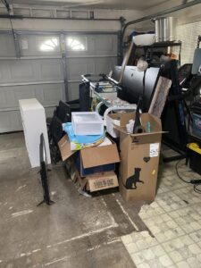 A cluttered garage filled with various items ready for a cleanout service by Impact Environmental Co. in El Cajon, CA.