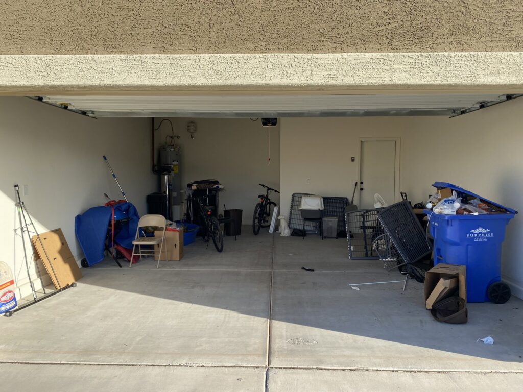 A cluttered garage filled with various items and debris, ready for a cleanout service by Canyon State Junk Removal in Peoria, AZ