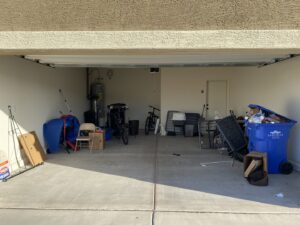A cluttered garage filled with various items and debris, ready for a cleanout service by Canyon State Junk Removal in Peoria, AZ