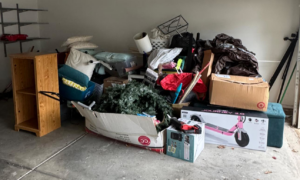 A cluttered garage with a large pile of various junk items awaiting removal by Junkjet in Charlotte, NC.