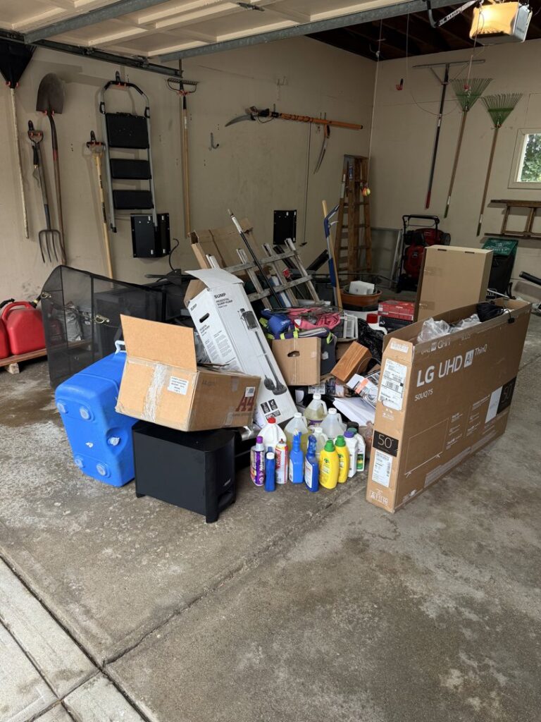 A cluttered garage with boxes, cleaning supplies, and other items, awaiting junk removal by Trash King LLC in Derry, NH.