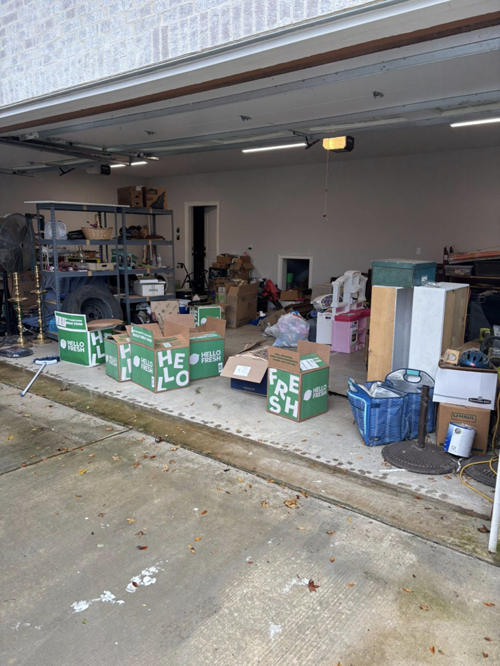 A cluttered garage filled with numerous boxes and household items, indicating a junk removal project for Nash's Cargo Company LLC in Shreveport, LA.