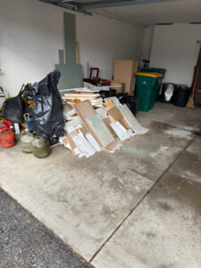 A cluttered garage filled with construction debris and trash for Black Diamond Junk Removal in Bedford Heights, OH.