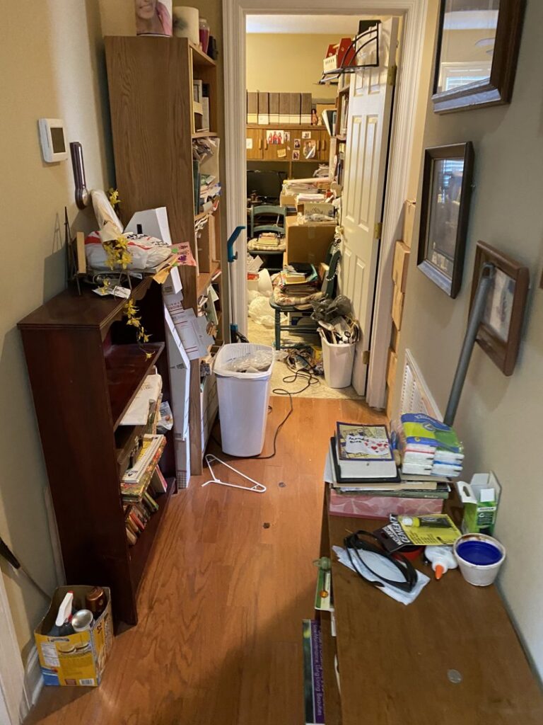 A cluttered hallway and room filled with boxes and items, indicating a space ready for junk removal by Valley Junk Removal in Huntsville, AL.