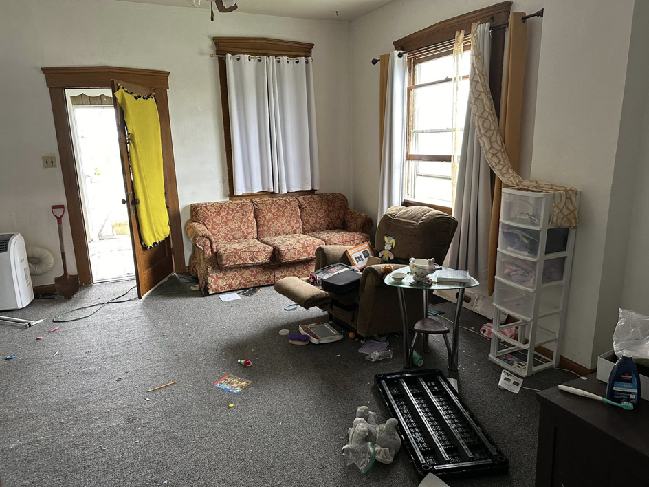 A cluttered living room with old furniture and scattered items, showing a scene before junk removal by Sinclair Waste Removal & Hauling LLC in St. Charles, MO.