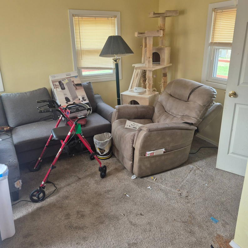 A cluttered living room with furniture and various items, indicating a need for junk removal by Siouxland Junk Removal in Sioux City, IA.