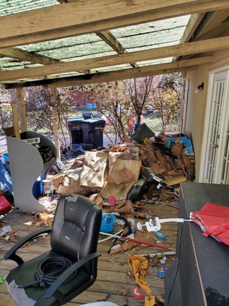 A cluttered outdoor patio with old furniture and debris, ready for cleanup by Sonny Day Junk Removal in Batesville, AR.
