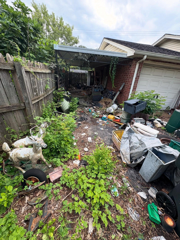 A cluttered and overgrown backyard filled with various junk and debris, ready for cleanup by Fargo's Junk Removal in Nashville, TN.