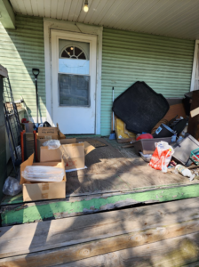 A cluttered porch filled with various items needing removal by C&J junk removal llc in Akron, OH.
