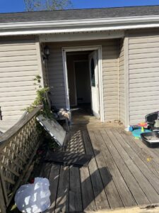 A cluttered porch and deck area with various items and debris awaiting junk removal by DC'S Removal Service in Neelyville, MO.