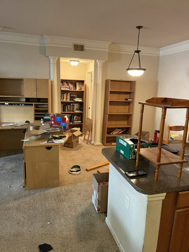 A cluttered room with old furniture and boxes, indicating a cleanout job for NTX Haul Away Junk Removal in Fort Worth, TX.