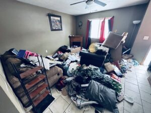 A heavily cluttered room in a house, indicating a major cleanout job for WeHaul Hauling & Junk Removal in Sioux Falls, SD.
