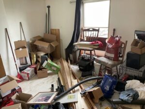 A room filled with household junk, boxes, and debris, awaiting removal by JB'S Junk Removal in Justin, TX.