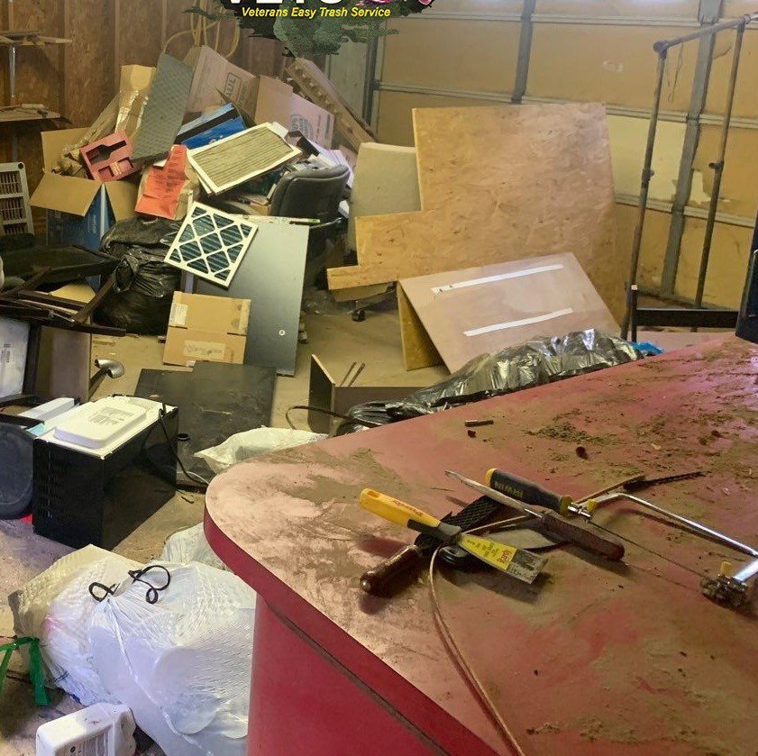 A cluttered room filled with boxes, wood panels, and various items for indoor junk removal by Veterans Easy Trash: Atlanta in Atlanta, GA.