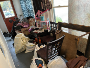 A cluttered room filled with various items and bags of junk, ready for removal by 2 Much Junk? Junk Removal in Grand Rapids, MI.