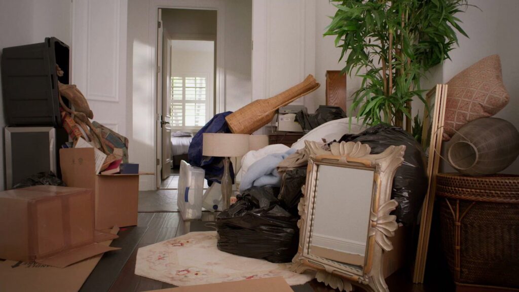 A cluttered room filled with various items and trash bags, ready for junk removal by Junk King in Greensboro, NC.