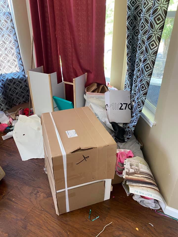 A cluttered room with boxes, disassembled furniture, and various items awaiting removal by Down and Dirty Junk Removal in Tacoma, WA.