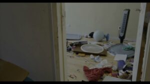 A room with various items, clothes, and debris scattered on the floor, indicating a junk removal job for Junk Movers in Salt Lake City, UT.