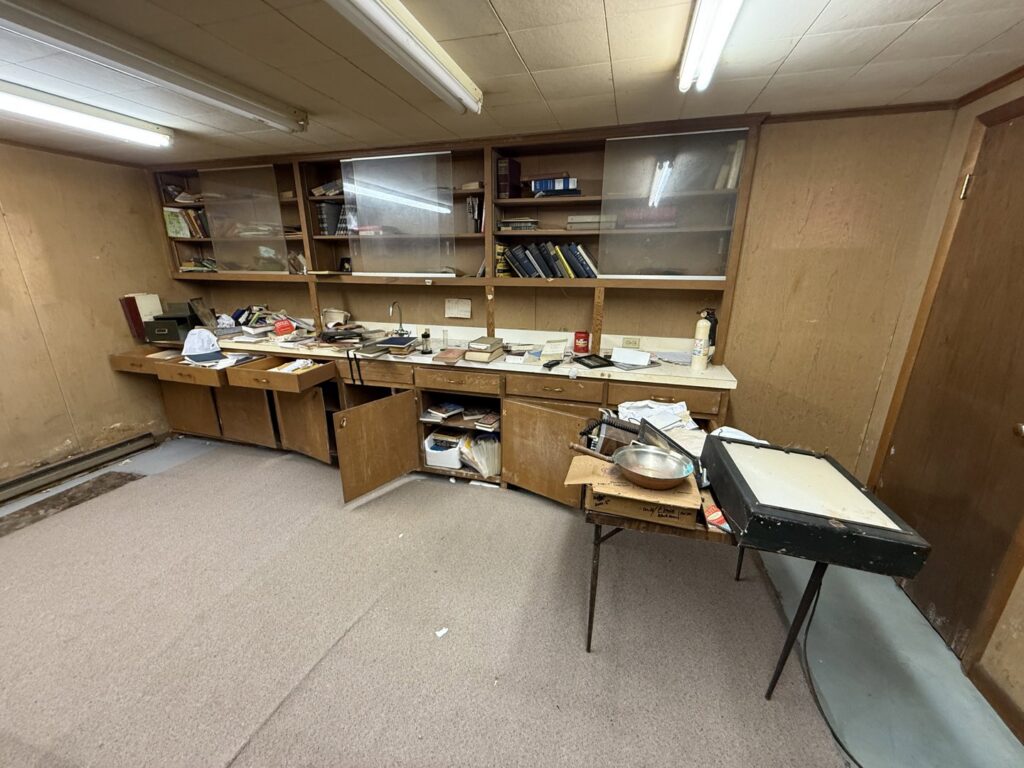 A cluttered room with shelves and cabinets full of items, indicating a need for junk removal by Clutter Bandit in Albany, NY.