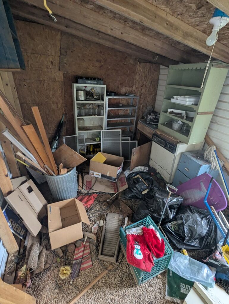 A heavily cluttered shed filled with various items and trash, awaiting junk removal by Valley Junk Removal in Huntsville, AL.